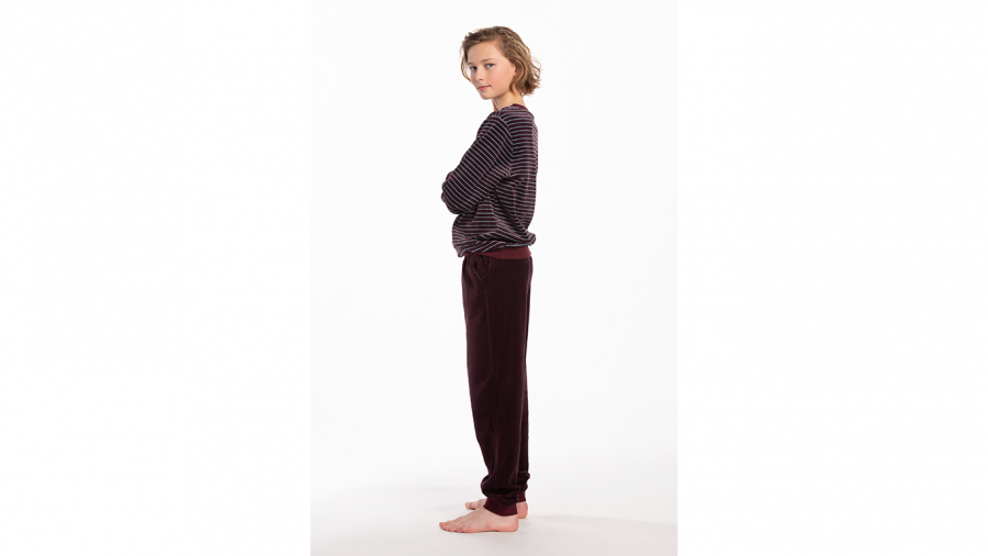 De fluwelen pyjama Pico van Eskimo is een droom van warmte en zachtheid. Zeer comfortabel, ideaal om in te slapen of als homewear. Zowel de enkels als de polsen hebben een elastische effen boord. De trui is bordeaux met fijne lichtblauwe strepen, De br