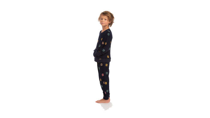 De pyjama Kolor Kastor van Eskimo in zachte badstof heeft een leuke allover print van gezichtjes met ogen en snorren op een marine blauwe achtergrond. De trui heeft een grote zak midden vooraan. Zowel de enkels als de polsen hebben een elastische effen