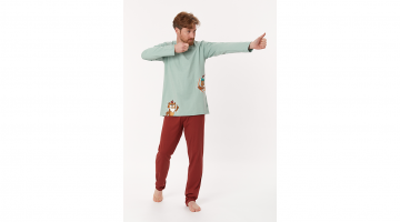 Deze Woody heren Pyjama van soepel, rekbaar jersey katoen is heel aangenaam en comfortabel om dragen. De muntgroene T-shirt met lange mouwen en ronde hals heeft een print van een uil met een appel op zijn hoofd, en een tweede uil die met pijl en boog mikt