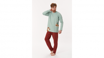 Deze Woody heren Pyjama van soepel, rekbaar jersey katoen is heel aangenaam en comfortabel om dragen. De muntgroene T-shirt met lange mouwen en ronde hals heeft een print van een uil met een appel op zijn hoofd, en een tweede uil die met pijl en boog mikt