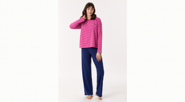 Dames Pyjama in een zachte katoen MOOD. De T-shirt met lange mouwen is een loszittend model, met fuchsia en witte strepen, en de broek is ook een loszittend model in effen blauw met een biesje aan de zijkant in het fuchsia zoals de t-shirt.