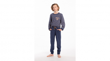 De Pyjama Saul van Eskimo voor jongens van 10 tot 14 jaar is een zachte en luchtige katoenen pyjama voor zoete dromen.  De T-shirt heeft lange mouwen, een ronde hals, allover strepen print, en tekst op de borst What's up!.  De effen donkerblauwe broek hee